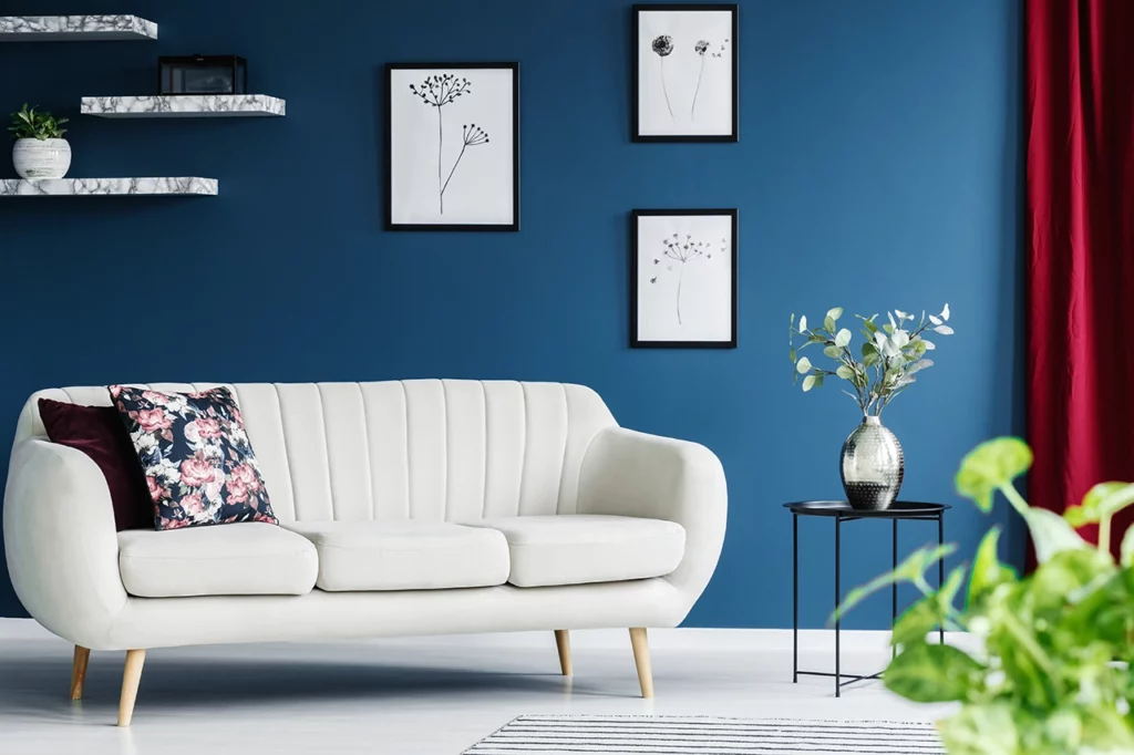 A living room with blue walls and a white sofa.